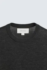 Jersey negro de lana y cashmere, de corte regular, cuello redondo y manga larga.