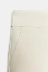 Shorts de tiro medio color negro, con bolsillos delanteros y falsos bolsillos con solapa en la parte trasera. Cierre frontal con cremallera y ganchos metálicos.