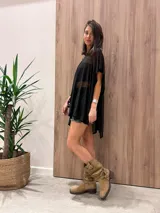 Poncho de punto grueso, color beige, con cuello redondo y diseño estampado en tonos tierra y negro.