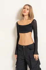 Blusa corta negra de mangas largas con transparencias y escote drapeado.