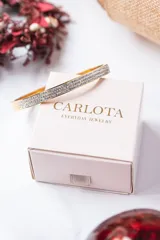 Brazalete rígido dorado con tres hileras de circonitas.
