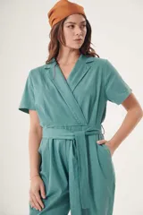 Mono largo celeste con cuello camisero, mangas cortas, corte cruzado con lazo en la cintura y bolsillos laterales.