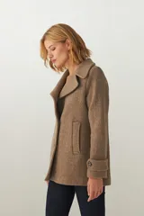 Chaquetón marrón de lana con cuello, abrochadura simple con botón en el cuello, bolsillos ojal y detalle de martingala en mangas.