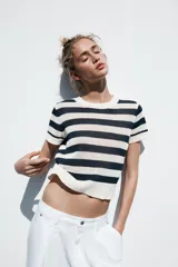 Top de punto celeste con rayas horizontales en azul. Tiene cuello redondo y mangas cortas.