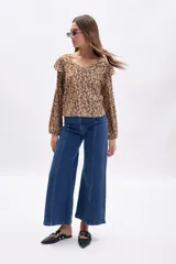 Pantalón de jean azul oscuro, corte ancho (wide leg), con costura frontal marcada en ambas piernas.