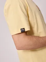 Remera blanca de algodón con estampa en la espalda con el logo de Rusty y la leyenda 'Since chasing surf records 1985'.