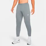 Pantalón largo deportivo Nike Challenger Knit para hombre, color gris con logo blanco en el muslo izquierdo. Corte ajustado con cintura elástica y cordón ajustable. Cuenta con bolsillos laterales y cierres en los tobillos.