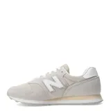 Championes urbanos New Balance modelo 373 para mujer, color gris claro/beige con detalles en blanco y cordones blancos. Presentan una combinación de gamuza y malla en el exterior.