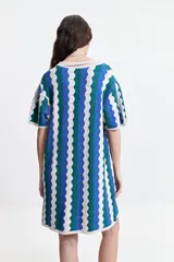 Vestido corto tejido de punto con cuello tipo camisa, botones frontales y diseño a rayas onduladas en tonos azul, verde y blanco.