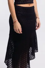Falda midi negra de encaje con corte irregular y ruedo asimétrico.