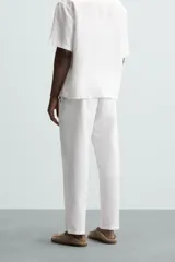 Pantalón azul marino de corte recto, con cintura elástica ajustable con cordón, bolsillos laterales y traseros.