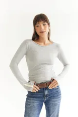 Cinto de cuero color marrón con hebilla metálica y tachas plateadas.