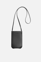 Bolso bandolera negro de cuero con bolsillo plano frontal y correa fina al hombro.