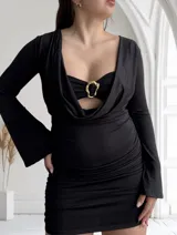 Vestido negro de tres piezas, compuesto por un top tipo corpiño con aro dorado, una falda mini fruncida y un cardigan de mangas largas.
