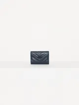 Billetera pequeña color visón, con solapa y cierre a presión. Diseño acolchado con pespuntes en forma de V y logo metálico con forma de labios.