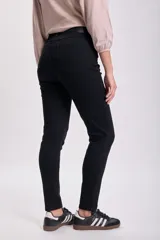 Pantalón de jean skinny negro, tiro alto, corte ajustado y largo al tobillo.