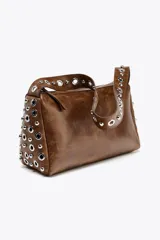 Bolso de hombro marrón con apliques metálicos plateados en los laterales y en la correa. Cierre con cremallera.