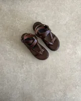 Sandalias de cuero vacuno color negro, con tiras finas y suela plana.