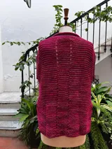 Chaleco negro tejido a mano en dos agujas con hilado 100% baby alpaca, ligeramente oversize, de hombros anchos y cuello tipo bote, con puntos calados en frente y espalda y tajos a los lados en el bajo.