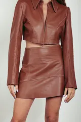 Campera corta de cuero ovino color caramelo, de mangas largas acampanadas y cuello camisero.