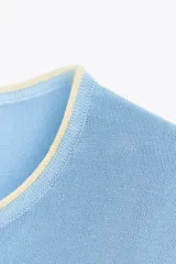 Remera blanca de punto con cuello redondo y mangas cortas con ribete negro en cuello, mangas y ruedo.