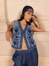 Chaleco de jean celeste con bordado floral monocromático en azul.