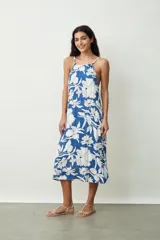 Vestido midi con estampado abstracto en tonos naranja y blanco, breteles finos y corte evasé.