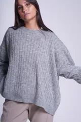Sweater oversize tejido en punto trenzado color gris, con cuello redondo y mangas largas.