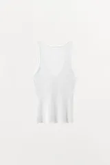 Musculosa blanca de algodón con escote en V y tirantes anchos. Tejido de punto calado en la parte superior y tejido de punto acanalado en la parte inferior.