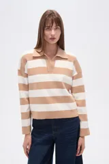 Sweater de tejido de punto, holgado, con rayas horizontales anchas en blanco y negro. Presenta cuello polo con escote en V y mangas largas.