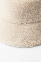 Gorro tipo bucket color crema, confeccionado en tejido efecto borreguillo con forro interior a tono.
