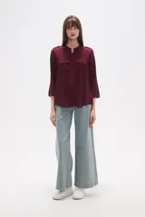 Camisa de manga larga con cuello mao y estampado paisley en tonos blanco, verde oliva y rosado. Presenta un calce holgado y bolsillos frontales.