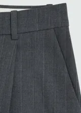 Pantalón de vestir gris con raya diplomática, tiro medio, corte recto y pinzas.