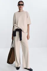 Camiseta color beige de corte amplio, cuello redondo y mangas cortas.
