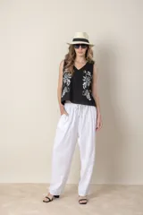 Blusa sin mangas de algodón color negro, con bordado floral blanco en el frente y escote en V.