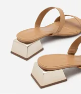 Sandalia mule color beige con dos tiras, puntera cuadrada y tacón bajo cuadrado cromado.