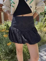 Minifalda negra de broderie con corte globo.