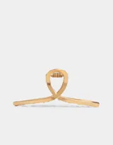 Broche metálico dorado para el pelo con forma de nudo.