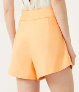 Short acampanado color naranja, de lino, con bolsillos y botón decorativo.