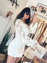 Vestido corto tejido a mano en dos hilos color crudo, con diseño de flores caladas y mangas amplias. Incluye body separado.