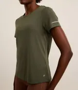 Remera deportiva color verde esmeralda, de cuello redondo y manga corta. Presenta detalle reflectante en la manga y pliegue en la espalda.