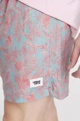 Short de baño celeste con estampado de hojas de palmera color salmón.