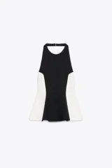 Top negro con cuello halter y espalda descubierta. Presenta detalle de combinación de tejidos en contraste con laterales blancos y bajo acabado en peplum.
