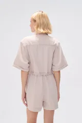 Mono corto blanco de algodón, con cuello camisero, cierre frontal con botones, mangas cortas y bolsillos.