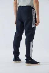 Pantalón de jogging gris oscuro de felpa con puños, cintura ajustable con cordón y logo estampado en la pierna.