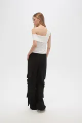 Pantalón cargo negro de viscosa, corte ancho y tiro alto, con bolsillos laterales y detalles de tiras colgantes.