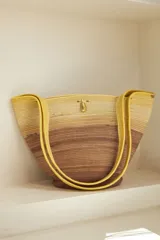 Bolso tipo tote confeccionado en soga de algodón color crudo, con asas de hombro y broche de bronce.