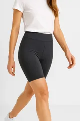 Short deportivo gris oscuro de poliamida, corte ajustado al cuerpo, tiro alto y largo a medio muslo.