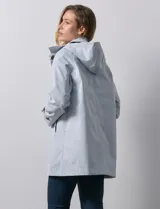 Gabardina color beige, impermeable, con abertura central con botones, bolsillos delanteros y capucha desmontable.