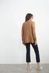 Ruana color tostado de tejido de punto, con corte holgado y diseño básico.